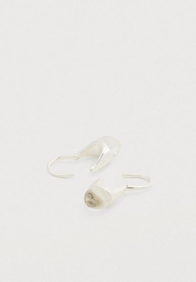 Ασημένια σκουλαρίκια κρίκοι με κυρτό σχέδιο και υφασμένες κεραμικές λεπτομέρειες σε αποχρώσεις εκρού και ανοιχτού γκρι.