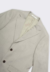 Blazer grigio chiaro in tessuto strutturato con rever a incavo, due bottoni marroni e fodera interna beige. Include tasche frontali.
