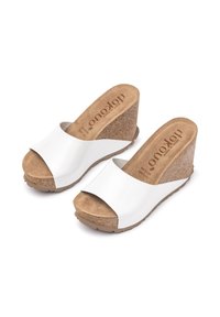 White wedge sandals with a smooth leather upper, cork midsole, and textured sole. Open toe design with a contoured footbed for comfort.