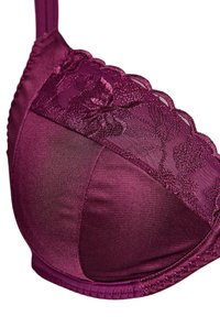 Burgundijas krūšturis ar ziedu mežģīņu apmalēm, gludām satīna līdzīgām krūšu daļām un dekoratīvām dūrēm gar malām.