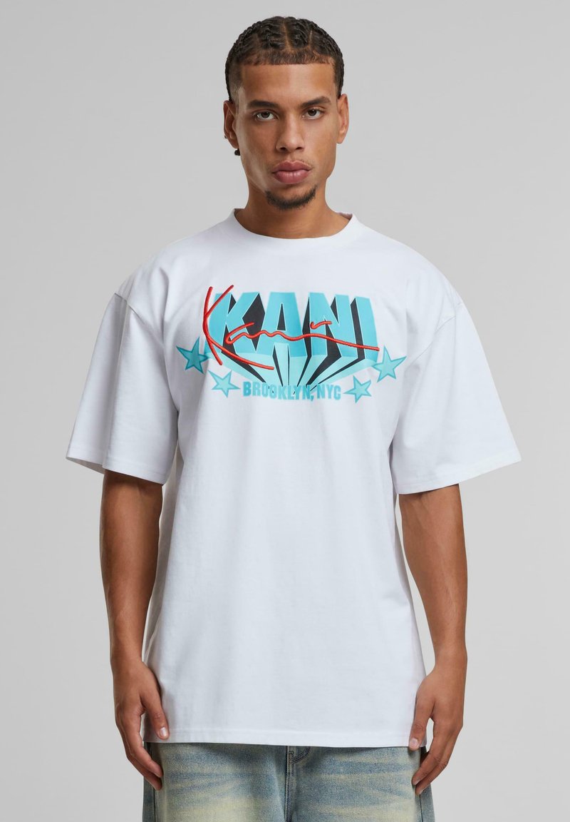 White short-sleeve T-shirt featuring bold turquoise and red graphic text with stars. Loose fit, made of soft cotton fabric.