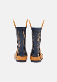 Bottes de pluie en caoutchouc bleu marine avec accents orange et poignées latérales, présentant un motif forestier doré. Texture lisse et hauteur mi-mollet.