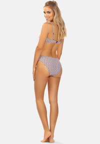 Zestaw bikini w jasnym geometrycznym wzorze, zawierający trójkątny biustonosz z regulowanymi ramiączkami oraz dolną część o niskim stanie, wykonany z elastycznej tkaniny.