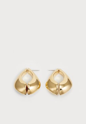 Pendientes de metal en tono dorado que presentan una forma redondeada única con un detalle recortado, acabado pulido y un soporte de perno para el cierre.