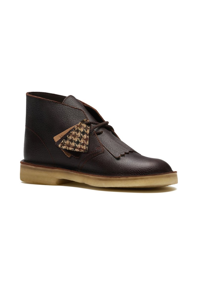 Brown leather ankle boots with a textured finish, contrasting light brown sole, and distinctive houndstooth pattern accent on the side.