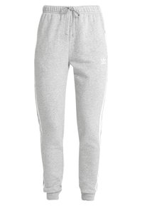 Pantalons de survêtement gris en tissu doux, dotés d'une taille avec cordon de serrage, de deux poches latérales et de rayures blanches sur les côtés. Design simple et fuselé.