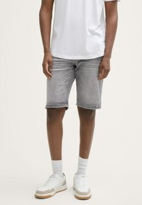 Grau denim Shorts mit regulärer Passform, umgeschlagenen Säumen und subtiler Verwaschung, kombiniert mit weißen Sneakers und knöchellangen weißen Socken.