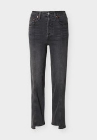 Μαύρο τζιν με ψηλή μέση, ραφές στο μπροστινό μέρος, πέντε τσέπες, κούμπωμα με κουμπί και ελαφρώς καμπανέ παντελόνια με σκισίματα μπροστά.