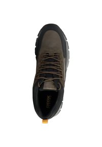 Scarpe da trekking marroni con accenti grigi, tomaia in materiale sintetico, collare imbottito e suola in gomma resistente. Presentano lacci marroni e un pratico tirante giallo.