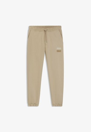 Beige sweatre pants lavet af blødt stof, med elastisk talje med snøring, sidelommer og et logo-patch på venstre lår.