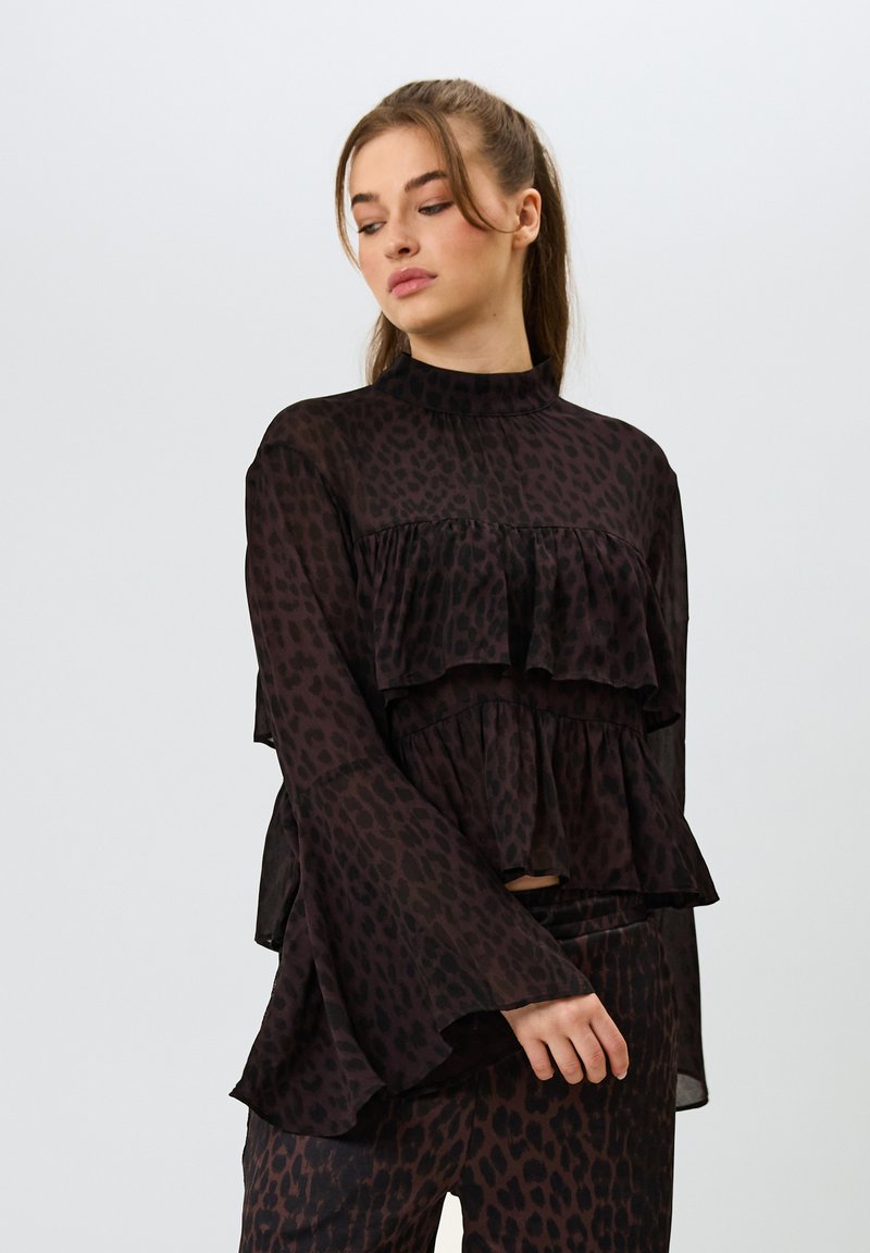 Musta leopardikuosis topp, jossa on kerrokselliset ryppyjat, korkea kaula-aukko ja kellotetut hihat, valmistettu kevyestä kankaan, yhdistettynä yhteensopiviin housuihin.