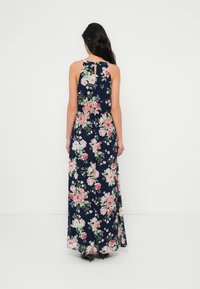 Virágmintás maxiruha, tengerészkék alapon rózsaszín és zöld rózsákkal. Ujjatlan kialakítás kulcslyuk hátoldallal és légies sziluettel.