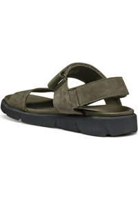 Sandales en daim vert olive avec une sangle réglable, à bout ouvert, et semelle en caoutchouc grise présentant un motif texturé, conçues pour le confort et la respirabilité.