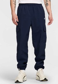 Marine cargo bukser lavet af letvægtsstof, med elastisk talje, sidelommer og manchetter. Kombineret med hvide sneakers.