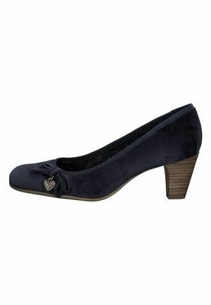 Navy blue suede pump with a rounded toe, bow detail, and heart-shaped charm. Features a medium wooden heel. Elegant silhouette.