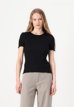 Svart t-skjorte med korte ermer og rund hals, med frynsete kanter, kombinert med stripete vide bukser. Jevn tekstur.