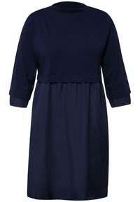 Marineblaues Kleid mit einem einfarbigen Oberteil, rundem Halsauschnitt und drei Viertel-Ärmeln sowie einem fließenden, gerafften Rock. Glatte Textur.