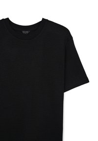 T-shirt nera a maniche corte in maglia testurizzata con collo rotondo e etichetta Calliope di taglia L visibile su sfondo bianco.