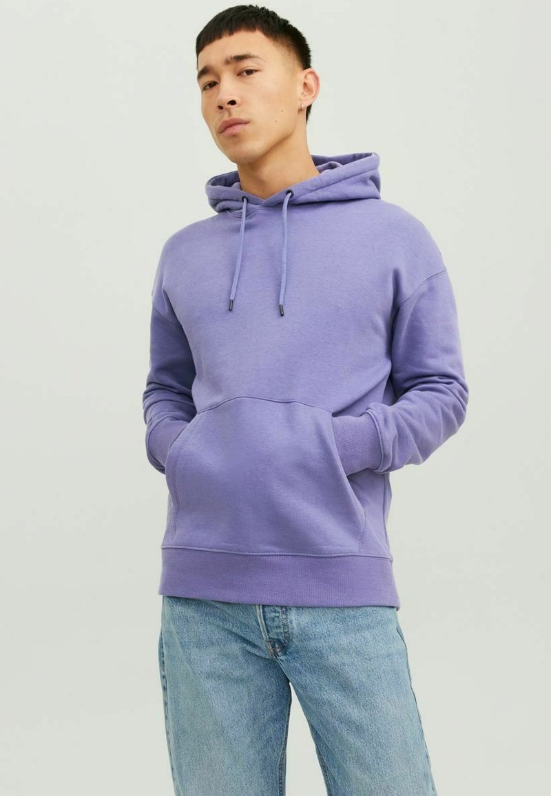 Felpa viola in morbido tessuto con tasca frontale, cappuccio con coulisse e polsini a costine, abbinata a jeans azzurri chiari. Design semplice e casual.