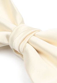 Crème satijnen vlinderdas met een gladde textuur, voorzien van een centrale geplooide knoop en puntige tips.