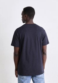 Navy blue cotton t-shirt with short sleeves, crew neck, and a relaxed fit. The fabric appears smooth, with no visible patterns or accents.