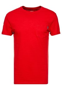 Rød bomulds t-shirt med korte ærmer, rund hals, enkelt brystlomme, let tekstureret stof og et mærketag på siden.