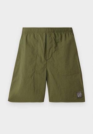 Zielone szorty z nylonu z elastycznym paskiem w talii, dwiema kieszeniami bocznymi oraz metką z logo "GAP" w białym kolorze na ciemnoszarym tle.