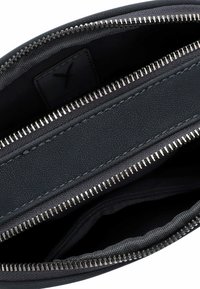 Borsetta in pelle nera con due scomparti in metallo argentato con zip, che mostrano la fodera in tessuto interna e i bordi cuciti.