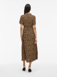 Rochie midi cu imprimeu leopardo, cu mâneci scurte, guler și o croială ușor lejeră. Prezintă un model maro și negru pe un fundal bej.