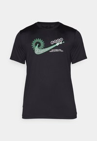 Černé sportovní tričko s grafickým designem v zelené barvě, obsahující text "just do it" a kruhový vzor, vyrobené z hladkého, prodyšného materiálu.