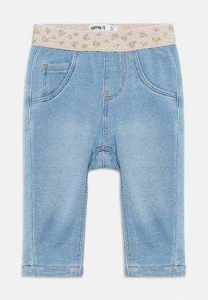 Pantalones para bebé de color azul claro con dos bolsillos delanteros y una cintura elástica beige decorada con puntos de purpurina dorada.