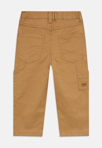 Καφέ cargo παντελόνι με κανονική εφαρμογή, δύο πίσω τσέπες, πλαϊνές τσέπες και υφασμένη ετικέτα στη δεξιά πλευρά. Λείος υφασμάτινος υφή.