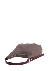 Bolso de ante de color topo suave con forma redondeada, asa de piel burdeos, cremallera plateada y un brillo sutil en la superficie.