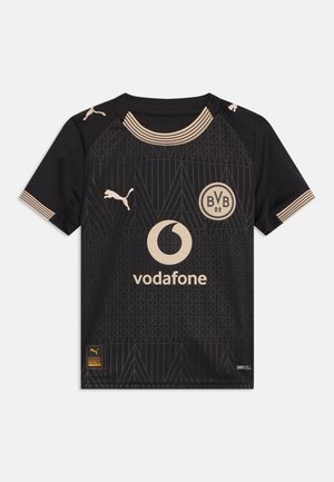 Maillot de football noir du Borussia Dortmund avec logos Puma beiges, sponsor Vodafone, motif géométrique, manches courtes et col et poignets rayés.