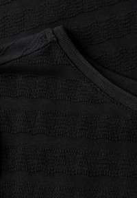 Tissu noir texturé avec des rayures horizontales, doté d'un col lisse et d'une construction générale en tricot.