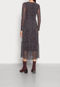 Dlouhý průhledný černý šaty s květinovým vzorem v modré a růžové barvě, vrstvená sukně, zkombinováno s bordovými kotníkovými botami na blokovém podpatku.