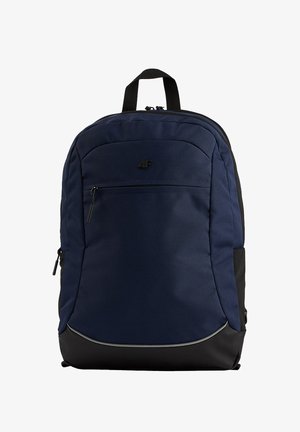 Granatowy plecak z czarną podstawą, przednią kieszenią na zamek, górnym uchwytem i małym czarnym logo na jednolitym białym tle.