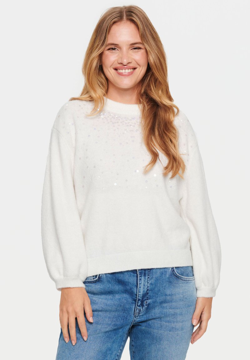 Maglione bianco con finitura testurizzata, dotato di scollatura rotonda e maniche a palloncino. Decorato con paillettes sparse sulla parte anteriore.
