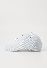 Baseballkasket med et stribet blåt og hvidt mønster, har en buet skygge, broderet logo på fronten og blå detaljer ved øjet.