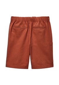 Shorts de couleur rouille avec une taille élastique, deux poches arrière et une poche cargo sur le côté pour un rangement supplémentaire. Texture de tissu lisse.
