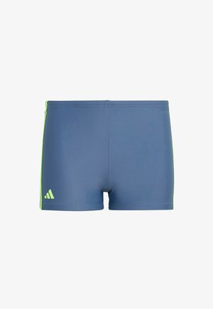 Pantalones cortos deportivos azules con una textura suave, con acentos laterales en verde neón y un pequeño logo blanco en la pierna izquierda.