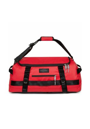 Borsa a sacca rossa con fascette, cerniere e dettagli neri. Presenta un ampio scomparto principale e una tasca frontale con cerniera. Materiale resistente.