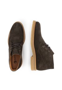 Bruine suède enkellaarzen met ronde neus, platte rubberen zool en twee gaatjes voor veters. Effen textuur met contrasterende stiksels.