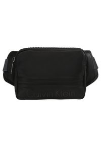 Schwarze Stoff-Taillentasche mit einem mit Reißverschluss versehenen Hauptfach, einer Fronttasche und geprägtem "Calvin Klein"-Logo. Texturierte Oberfläche und verstellbarer Gurt.