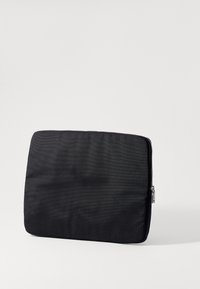 Funda de portátil negra con un exterior texturizado y un zipper plateado. Forma rectangular, acolchada para protección, adecuada para dispositivos.