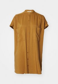 Camicia gialla senape a bottone corta con colletto alla cinese, maniche corte arrotolate e texture a righe verticali. Due taschini frontali.