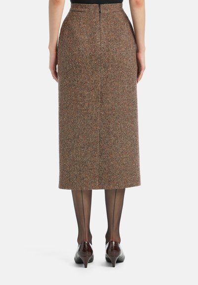 Fustă din lână cu model houndstooth în nuanțe de maro, cu puncte roșii și portocalii. Are o croială dreaptă, midi, și închidere cu fermoar la spate.