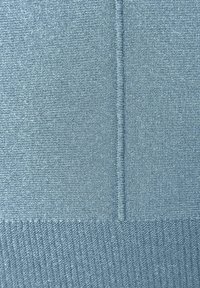 Hellblau strukturierter Stoff mit einem glatten Strick oben und einem gerippten Abschnitt unten, versehen mit zwei vertikalen Nahtlinien.
