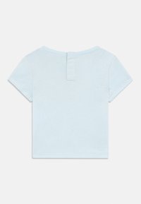 Ανοιχτό μπλε κοντομάνικο πουκάμισο φτιαγμένο από απαλό βαμβάκι, με μικρό άνοιγμα στη μέση της πλάτης και καθαρές ραφές. Μινιμαλιστικός σχεδιασμός χωρίς σχέδια.