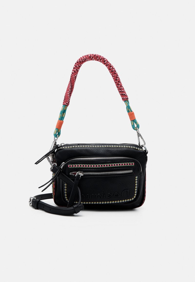 Musta nahkainen olkalaukku, jossa on kaksi vetoketjullista lokeroa, punavihreä punottu olkahihna ja koristeellinen ompelu reunoilla.